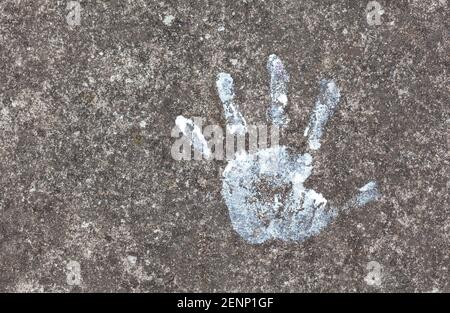 Colorful painted childs hand print on the concrete floor symbol. Small, little child's handprint reflected on the ground with paint. Arts, crafts, cre Stock Photo