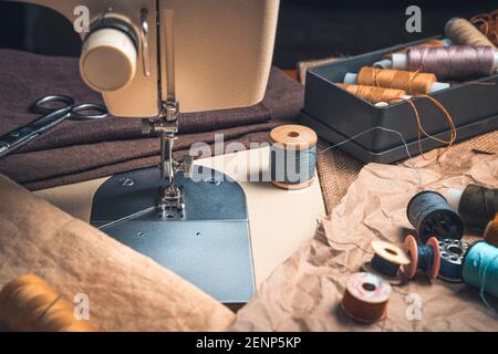 A close-up sewing machine and a set of threads. Side view, vintage finish. Stock Photo