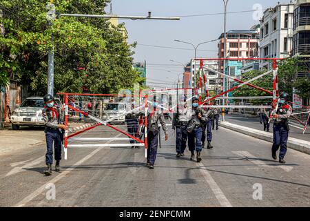 Mandalay, Myanmar. 26th Feb, 2021. Police carry barricade to block the street during an anti-coup demonstration.Myanmar Security Forces shot at anti-military coup protesters and those close to them with slingshots, rubber bullets and other materials thus injuring young children and many were arrested. Credit: SOPA Images Limited/Alamy Live News Stock Photo