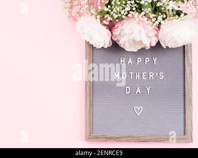 Happy mothers day greetings on letter board on pink background Stock