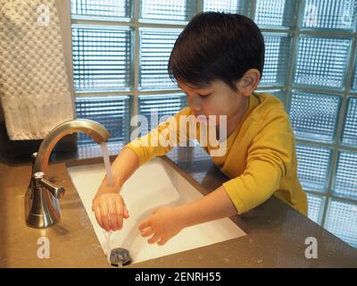 A boy washes his hands Stock Photo