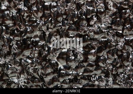 Black Expanded polyethylene foam sample background. EPE beads packing material with macro details, textures and one solid color. Stock Photo