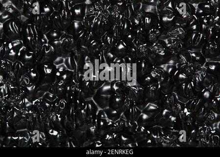 Black Expanded polyethylene foam sample background. EPE beads packing material with macro details, textures and one solid color. Stock Photo