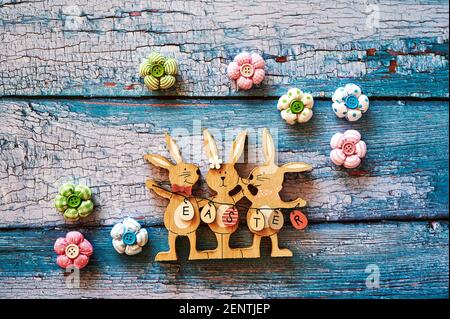 Wooden Easter bunnies with decoration and the text Easter written on eggs. Stock Photo