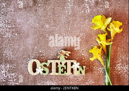Wooden sign with an Easter bunny with flowers as decoration. The Text is German for Easter. Stock Photo