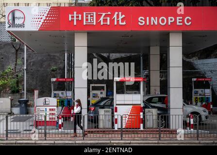 A pedestrian walks past the Chinese oil and gas enterprise China Petroleum & Chemical Corporation, known as Sinopec, gas station seen in Hong Kong. Stock Photo