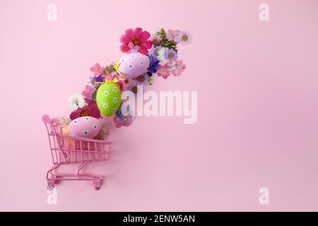 Happy Easter big hunt or sale banner with Colorful Eggs in shopping cart on pink background. Stock Photo