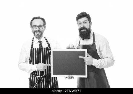 cafe and restaurant opening. menu planning. happy chef team in apron. catering business. welcome on board. partners celebrate start up. bearded men with blackboard, copy space. cafe menu presenting. Stock Photo
