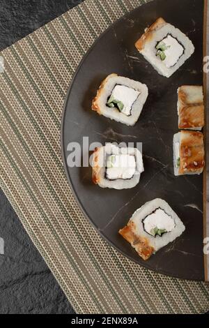 Tasty dragon sushi rolls with eel on black plate Stock Photo