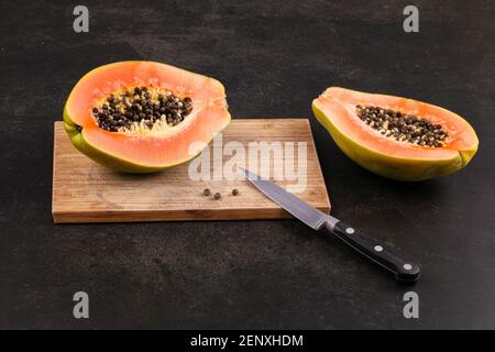 Exotic fruit papaya cut in half on black background Stock Photo