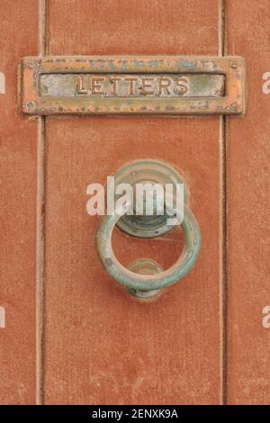 Simple traditional brass Maltese door knocker and letter box in Valletta, Malta Stock Photo