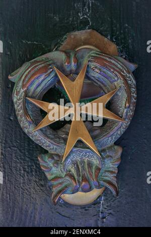 Traditional brass Maltese cross-shaped door knocker in Valletta, Malta Stock Photo