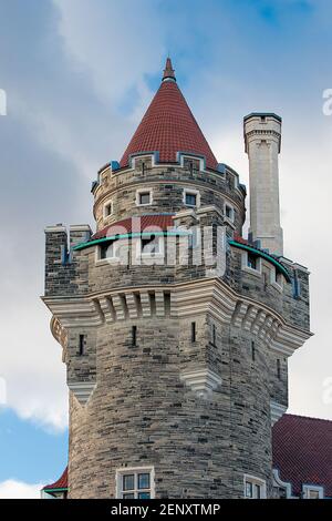 Casa Loma Gothic Revival Medieval Castle: Part of the old castle a round tower with a chimney over sky with clouds Stock Photo