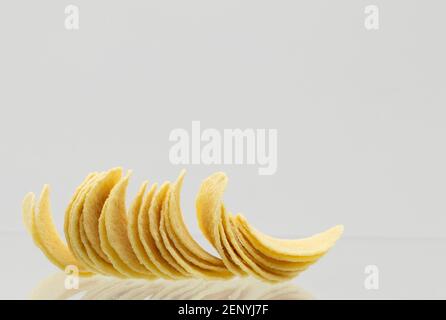 Crispy delicious potato crisps chips snack on a gray background with reflection Stock Photo