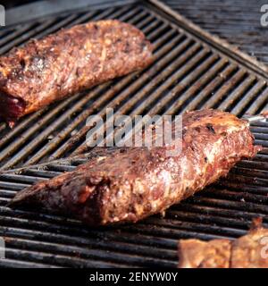 Food background with barbecue party. Ribs cooking on barbecue grill for summer outdoor party. Stock Photo