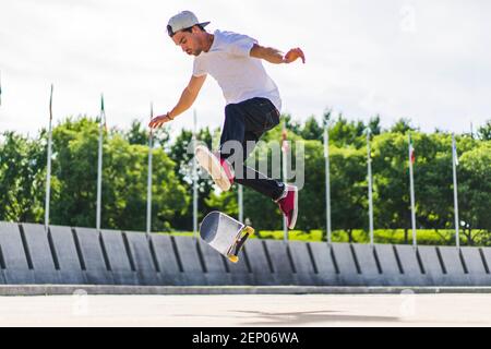 Young skateboarder doing a flip trick on ground, Montreal, Quebec, Canada Stock Photo