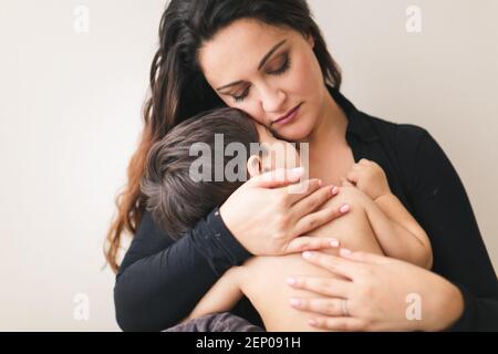 Mom holding her sleeping son close to her chest. Stock Photo