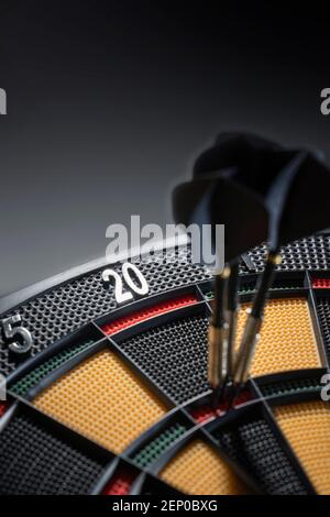 Close up of three darts in triple 20 of dartboard.Ton 80. Black Darts Stock Photo