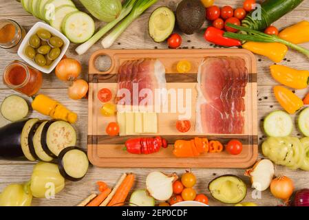 Ham on serving  board in colorful food vegetable frame. Stock Photo
