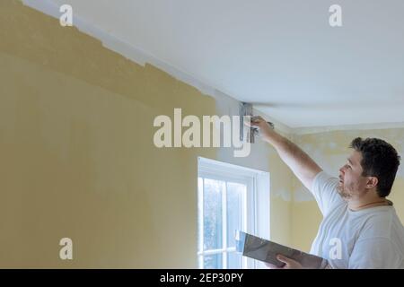 Work hand tool wall using plastering tool for unfinishing wall Stock Photo