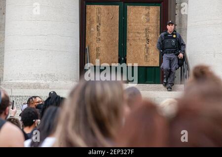 Ohio State Trooper stands on the steps of the Ohio Statehouse during the demonstration.Protesters gathered in front of the Ohio Statehouse and marched north on High St. in a demonstration against police brutality, racism and the killing of George Floyd by Minneapolis Police Officer Derek Chauvin on May 25, 2020. Stock Photo