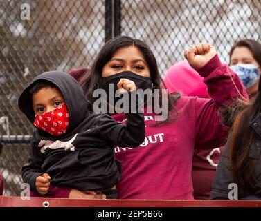 Washington, DC, USA, 26 February, 2021.  Pictured:  A mother and her child raise their fists in solidarity with other workers calling for a $15 minimum wage at a Raise the Wage rally outside the White House.  Credit: Allison C Bailey/Alamy Live News Stock Photo