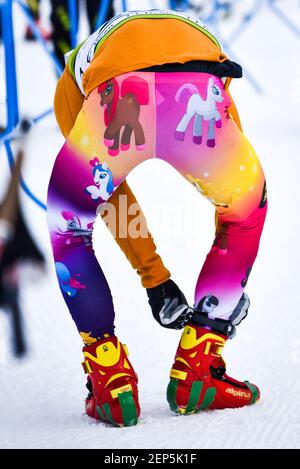 Cross country ski racer in striking My Little Pony tights adjusts equipment before the start of a race, Craftsbury Outdoor Center, VT, USA. Stock Photo