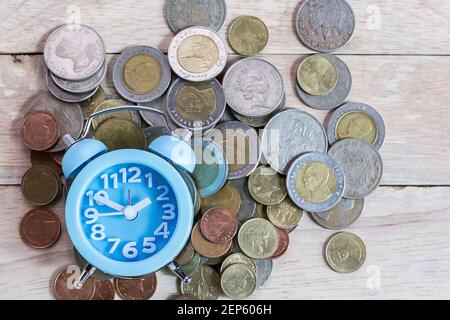 Coins,alram clock and pencil with empty notebook on wood table background. Office desk with money coins and business financial planning concept Stock Photo