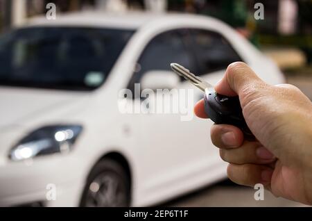 Femalel hand holding car key ready to start a new car with blurred car ...