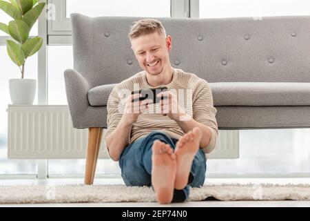 Man plays games on smartphone Stock Photo