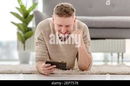 Man plays games on smartphone Stock Photo