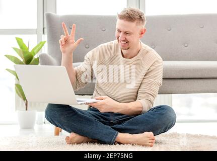 Man talking online using webcam on laptop Stock Photo