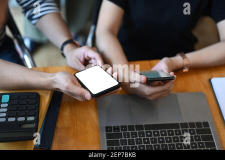 Cropped shot of two business using their smartphones looking for information  for working on the internet. Stock Photo