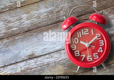 Close up red alarm clock wood background. Top view with copy space. Stock Photo