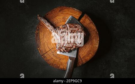 grilled cowboy beef steak on a dark background. expensive marbled beef of the highest grade fried to rare on the grill Stock Photo