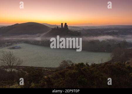 Corfe Castle, Dorset, UK.  27th February 2021.  UK Weather.  Light mist surrounds the ruins of Corfe Castle in Dorset on a cold frosty morning shortly before sunrise.  Picture Credit: Graham Hunt/Alamy Live News