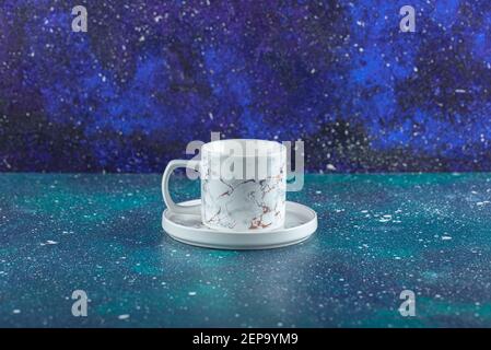 White porcelain cup on blue background Stock Photo