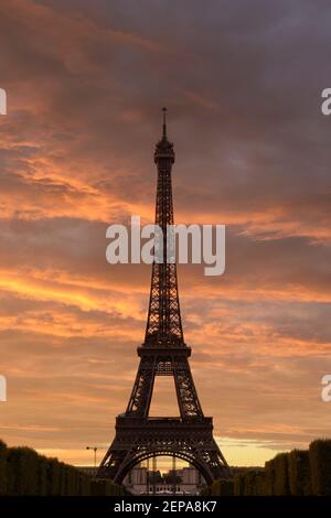 A fiery sunset ignites the sky behind the iconic Eiffel Tower in Paris, France. Stock Photo