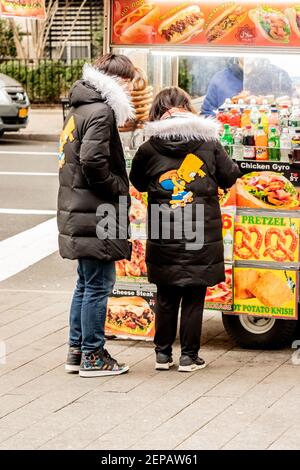 asian couple in identical Simpsons coats at food stands outside of New York The Metropolitan Museum of Art in NYC Stock Photo