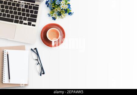 Modern White office workspace with eye glasses,laptop computer,pencil and cup of coffee. Top view with copy space.Office supplies and gadgets on works Stock Photo