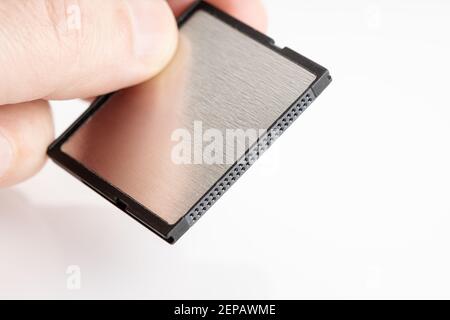 Hand holding a Compactflash memory card on white background. Photographic equipment. Copy space Stock Photo