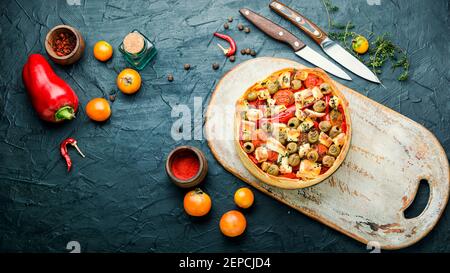 Appetizing tart with cheese, peppers and olives Stock Photo