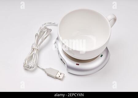electronic usb hub and heater for cup coffee or tea at office. digital usb warmer device on grey background. Stock Photo