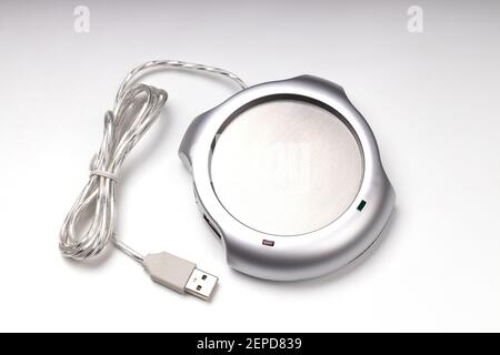electronic usb hub and heater for cup coffee or tea at office. digital usb warmer device on grey background. Stock Photo