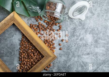 Bunch of coffee beans on marble background with empty wooden frame Stock Photo