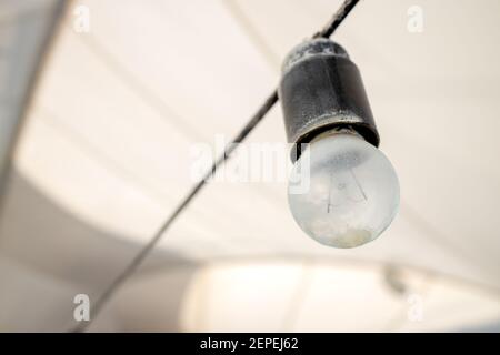 alone vintage light bulb at gray tent background. vintage lighting equipment Stock Photo