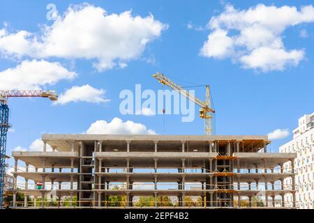 Apartment building construction. industrial cranes at blue sky Stock Photo