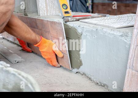 worker pushing the tile into the cement. renovation concept Stock Photo