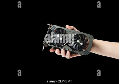 man hold graphic gpu video adapter isolated on a black background. hardware for processing with computer graphics Stock Photo