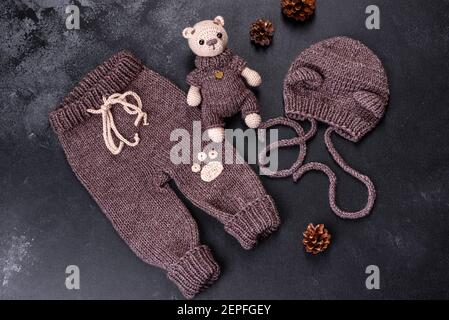 Toy bear tied from woolen threads on a dark background. Manual work, hobby Stock Photo